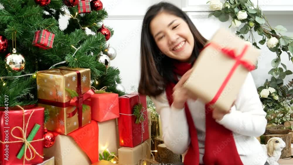 Woman surprise got present gift box on christmas eve. Asian woman holding christmas gift box under xmas tree with smiling face. Woman hands wrap present gift. Merry christmas happy new year concept Woman surprise got present gift box on christmas eve. Asian woman holding christmas gift box under xmas tree with smiling face. Woman hands wrap present gift. Merry christmas happy new year concept