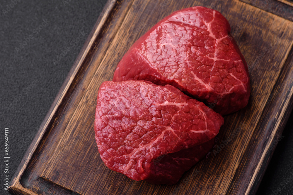 Fresh juicy raw beef medallions with salt and spices Fresh juicy raw beef medallions with salt and spices