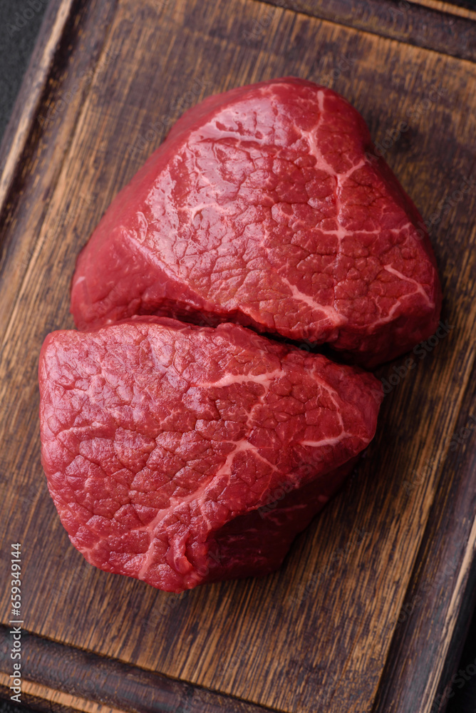 Fresh juicy raw beef medallions with salt and spices Fresh juicy raw beef medallions with salt and spices