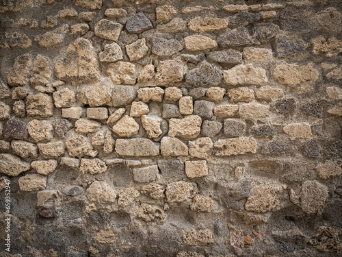 An old wall made of bricks that have been eroded by time.