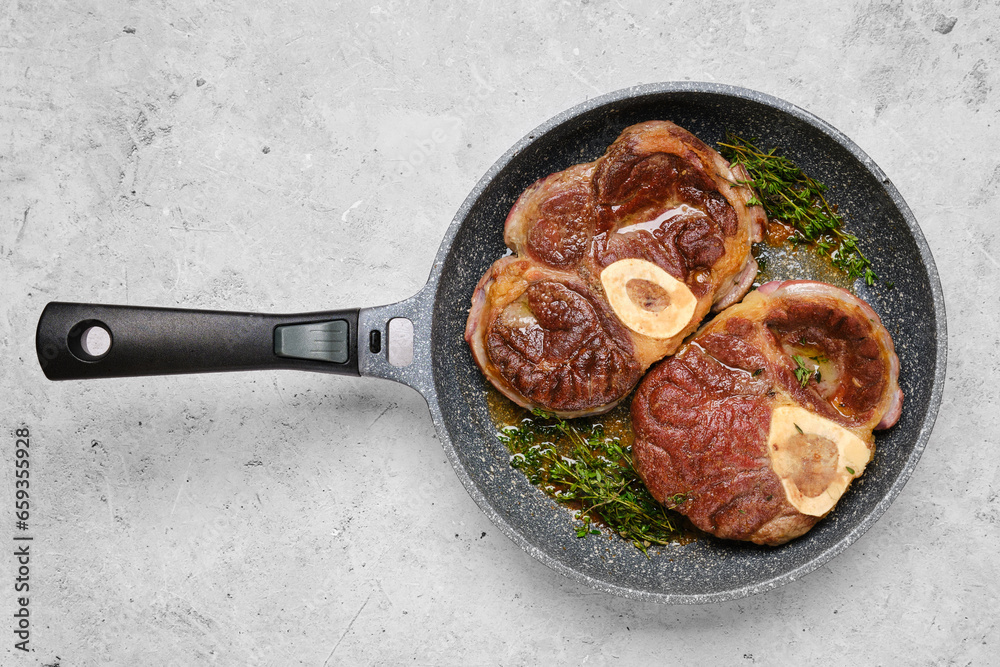 Ταπετσαρία Two pieces of beef ossobuco in a frying pan with thyme