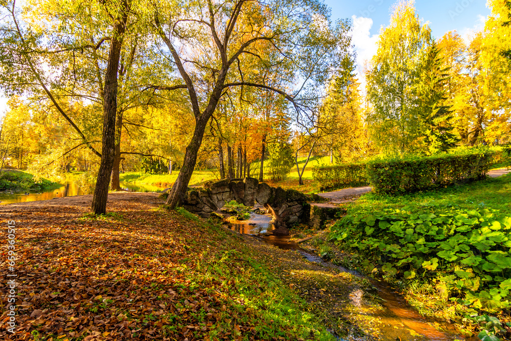 Humpbacked bridge and autumn foliage in Pavlovsky Park, Pavlovsk, St. Petersburg, Russia