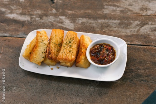 A plate of Indonesian pisang goreng tepung or fried banana with chilli sauce snack in white plate photo