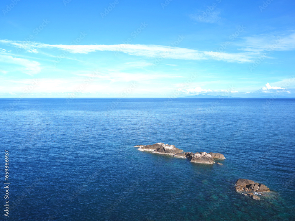 rocks on summer sea and blue sky background. rocks on summer sea and blue sky background.