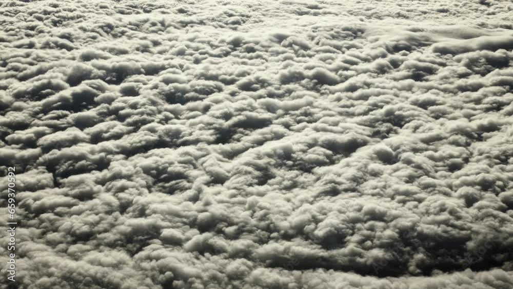 Aerial, view of planet earth from airplane window. Looking down on puffy clouds over Atlantic ocean on earth from airplane flying above the earth in cinematic slow motion. Aerial, view of planet earth from airplane window. Looking down on puffy clouds over Atlantic ocean on earth from airplane flying above the earth in cinematic slow motion.