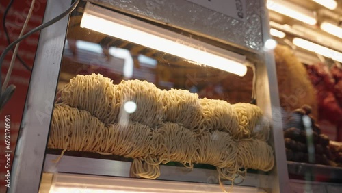 Raw bakmie noodle display on glass cart handheld photo