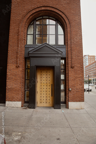 entrance of brick building with portico and arch window in downtown of new york  urban architecture