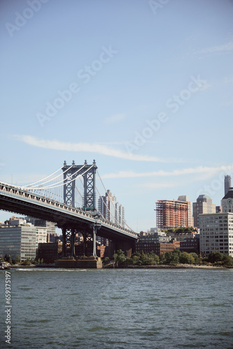 Manhattan bridge over east river and scenic new york cityscape with modern skyscrapers, autumn scene