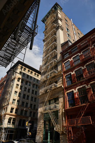 building with fire escape stairs on autumnal street in downtown of new york city, low angle view © LIGHTFIELD STUDIOS