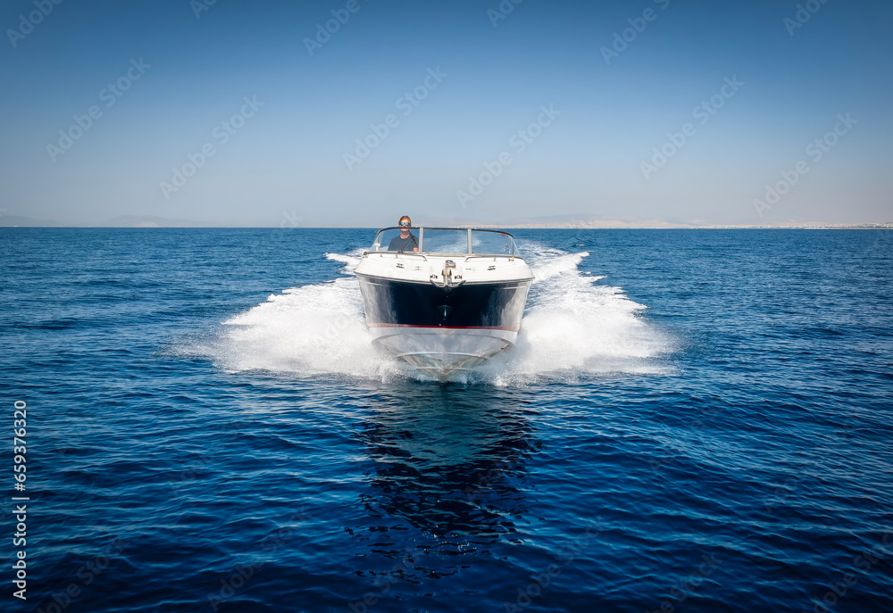 Fototapeta premium Front view of a sports motor boat cruising with high speed over the blue ocean