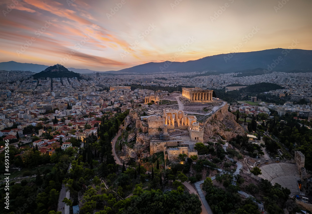 Aerial view of the illuminated Parthenon and Athena Nike Temple at the Acropolis of Athens, Greece, during golden sunrise
