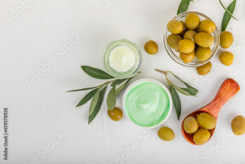 Jar of natural olive cream with olive oil extract on a texture background. Cosmetic tube. Moisturizing cosmetic cream for skin. Body care. Beauty concept. Copy space. Flat lay. Hand cream.
