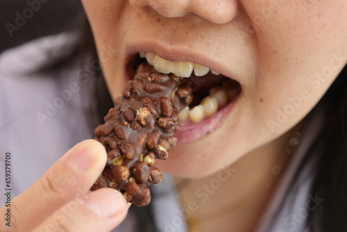 Close-up view of mouth eating food, Close-up view of mouth eating chocolate © komthong wongsangiam
