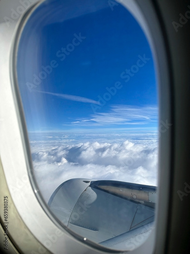 Airplane is flying among the white clouds in the blue sky