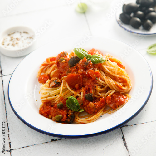Traditional pasta with tomatoes, olives and anchovy