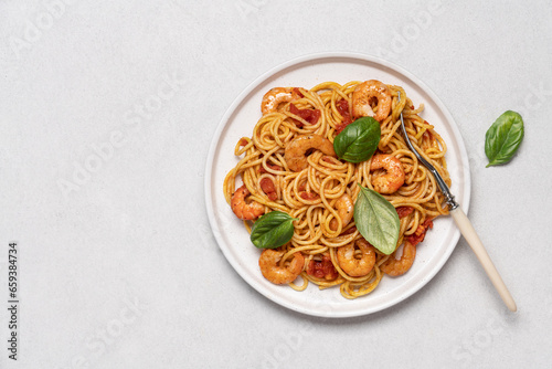 Shrimp marinara sauce pasta in plate on white background with copy space. Seafood spaghetti, Mediterranean cuisine