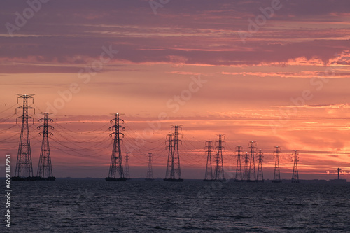 High voltage transmission tower and sunset