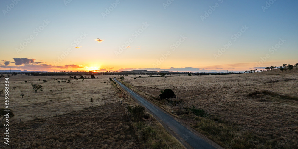 Road across cattle grazing farmland near Rockhampton, Queensland, Australia