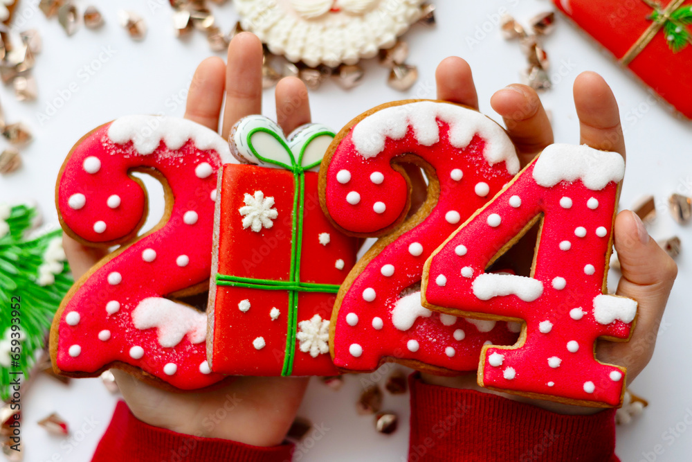 Banner for Christmas and New Year gingerbread cookies numbers 2024 on white background in child hands