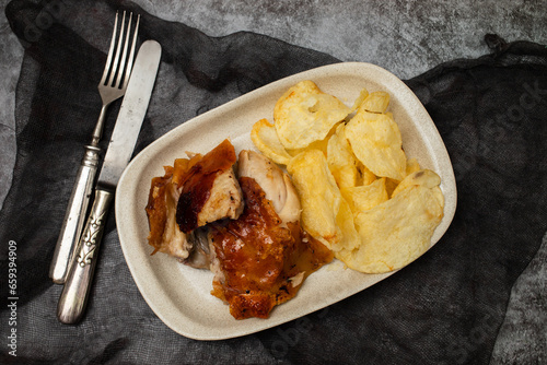 crispy tasty baked piglet and potato in ceramic dish photo