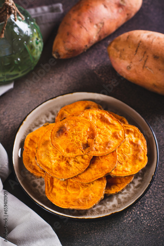 Homemade sliced baked sweet potato on a plate on the table vertical view