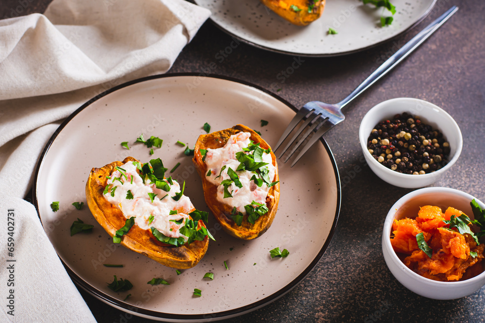 Baked sweet potato filled with ricotta, tomato and parsley on a plate Baked sweet potato filled with ricotta, tomato and parsley on a plate