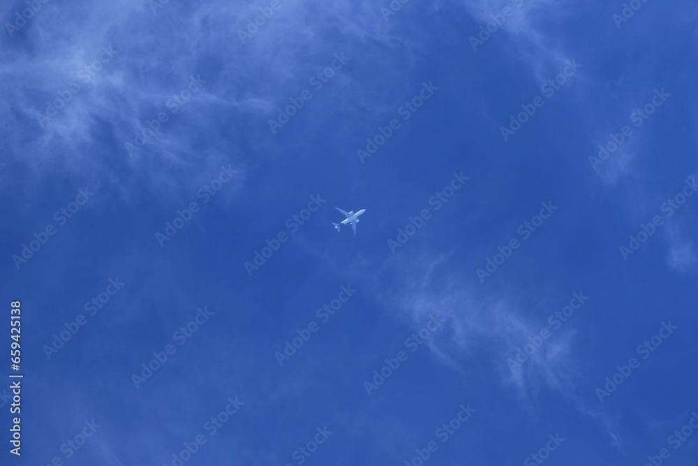 Fototapeta premium Airplane in the blue sky with white clouds 