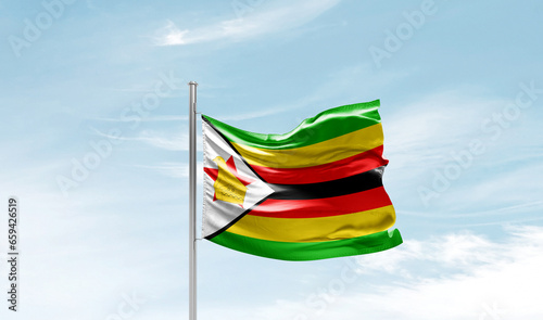 Zimbabwe national flag waving in beautiful sky. The symbol of the state on wavy silk fabric.