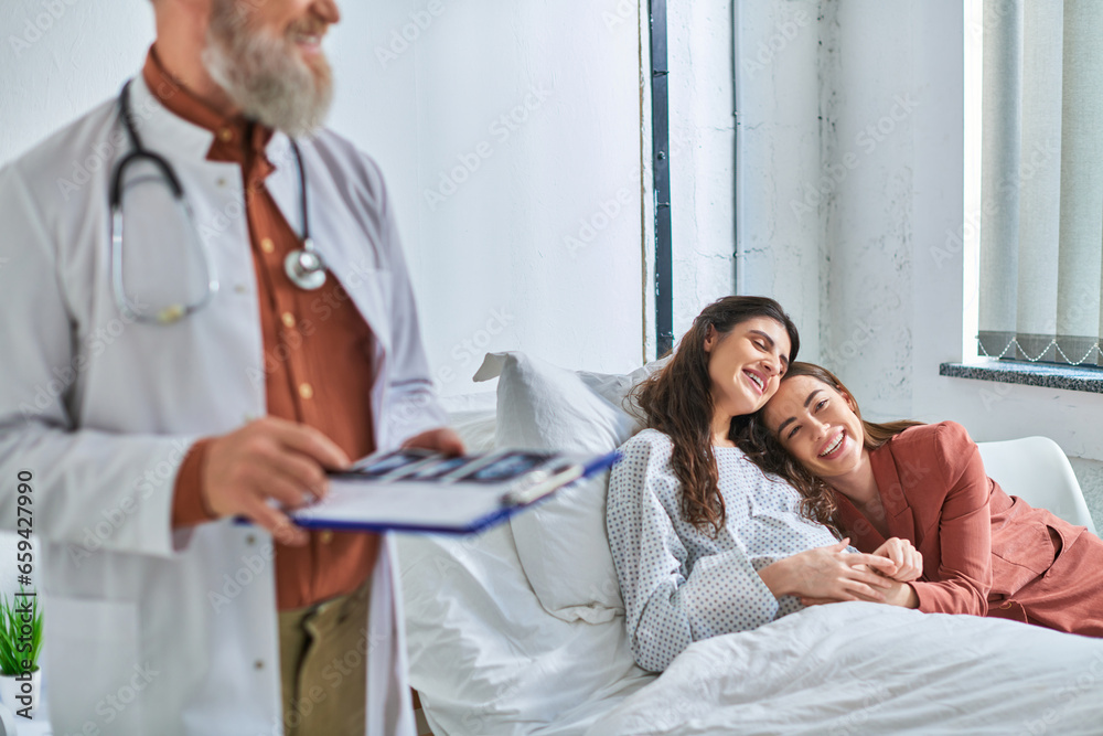 cropped view of doctor holding ultrasound with hugging lgbt couple on background, ivf concept cropped view of doctor holding ultrasound with hugging lgbt couple on background, ivf concept