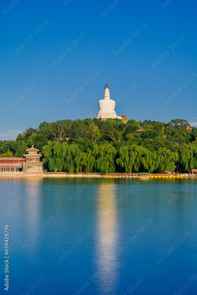 The white pagoda in Beihai Park in Beijing is reflected in the calm water. The white pagoda in Beihai Park in Beijing is reflected in the calm water.