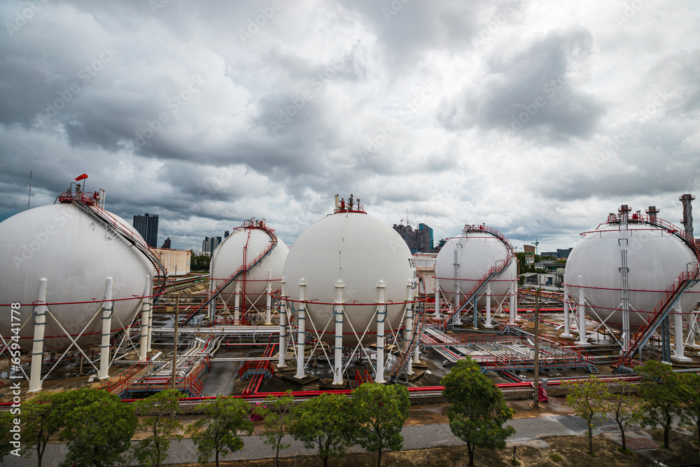 White spherical propane tanks containing fuel gas storm cloud
