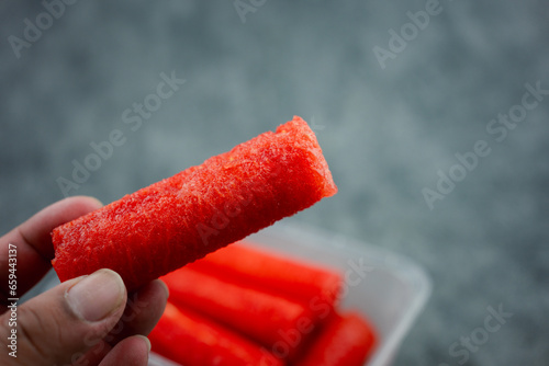 Seedless watermelon make to cylindrical for easy eating on man hand. Close up