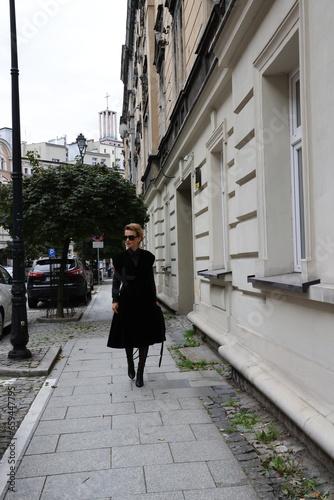 Dojrzała, elegancka kobieta na miejskim spacerze. Kobieta w czerni. 
