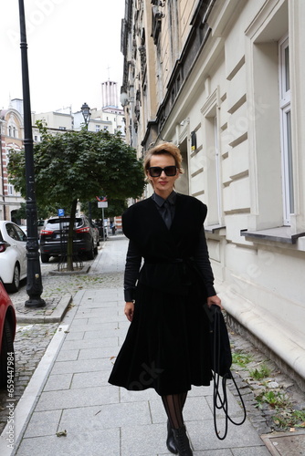 Dojrzała, elegancka kobieta na miejskim spacerze. Kobieta w czerni. 