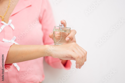 Young woman's hand holding a perfume bottle, alluring, beauty, perfume smell