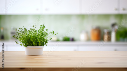 Green herb in white flower pot on wooden table - detail from modern home kitchen