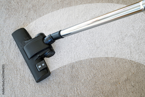 Vacuum cleaner cleaning a streak on a carpet to eliminate dirt and allergy causing house dust mites, copy space, selected focus