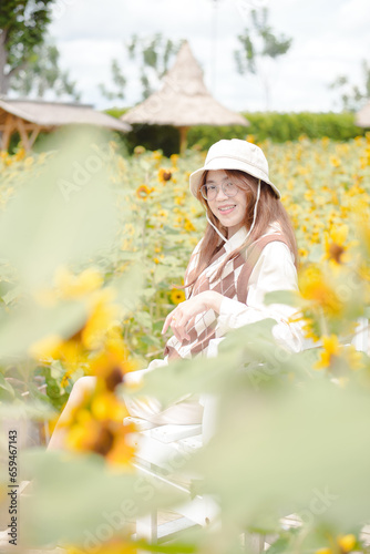 Portrait young woman in a field of sunflowers, Happiness asian woman in a field of sunflowers, Portrait asian woman in a field of sunflowers 