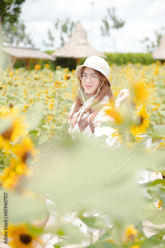 Portrait young woman in a field of sunflowers, Happiness asian woman in a field of sunflowers, Portrait asian woman in a field of sunflowers 