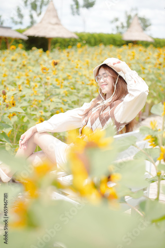 Portrait young woman in a field of sunflowers, Happiness asian woman in a field of sunflowers, Portrait asian woman in a field of sunflowers 
