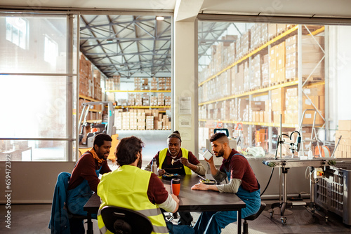 Group of young and diverse workers having a lunch break in a warehouse