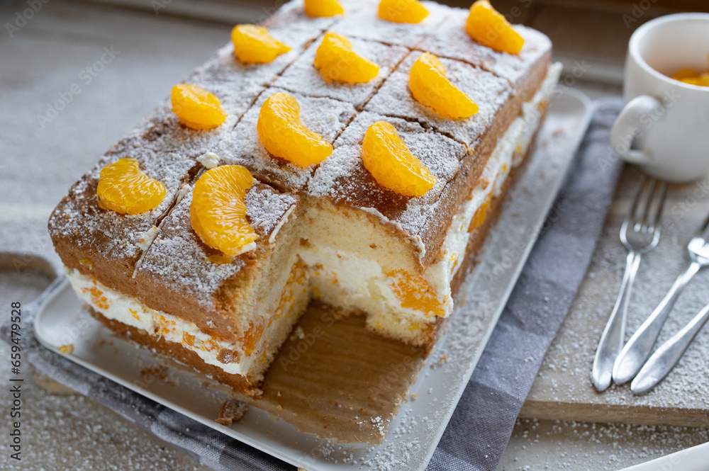 Orange cake with cream and tangerines on a white background. Orange cake with cream and tangerines on a white background.