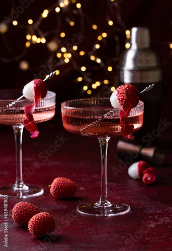 Lychee cocktail with fresh fruits. Christmas lights on the background