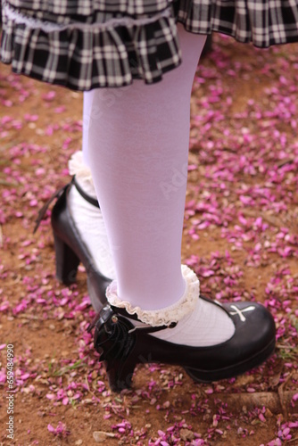 legs of woman wearing classic heel and withe collant in spring, walking in the park