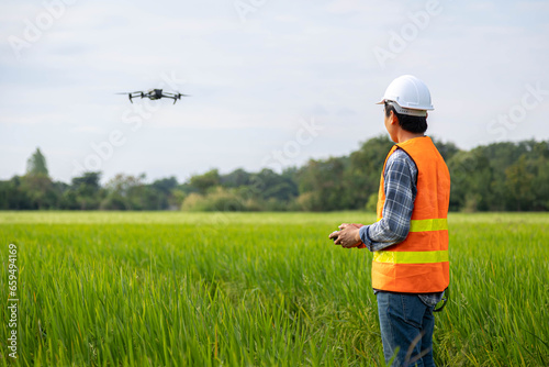 Agricultural specialist controls agriculture drone with remote controller for survey and data analysis data in rice fiel. Agriculture 5g, Smart farming, Smart technology concept.