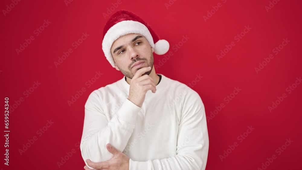 Young hispanic man wearing christmas hat having idea over isolated red background Young hispanic man wearing christmas hat having idea over isolated red background