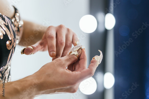 Fotografie Hands of drag queen applying sparkling false nails