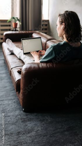 Young Woman Engages with Laptop at Home. Embrace the Potential of Freelancing, Student Lifestyle, Education, Web Conferencing, Video Calls, Technology, and Online Shopping with a Blank White Screen.