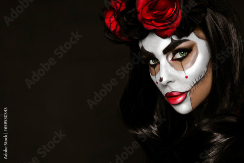 Portrait of a woman with sexy skull makeup over black background. Halloween costume and make-up. Portrait of Calavera Catrina