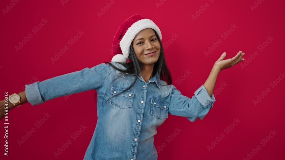 African american woman wearing christmas hat dancing over isolated red background African american woman wearing christmas hat dancing over isolated red background